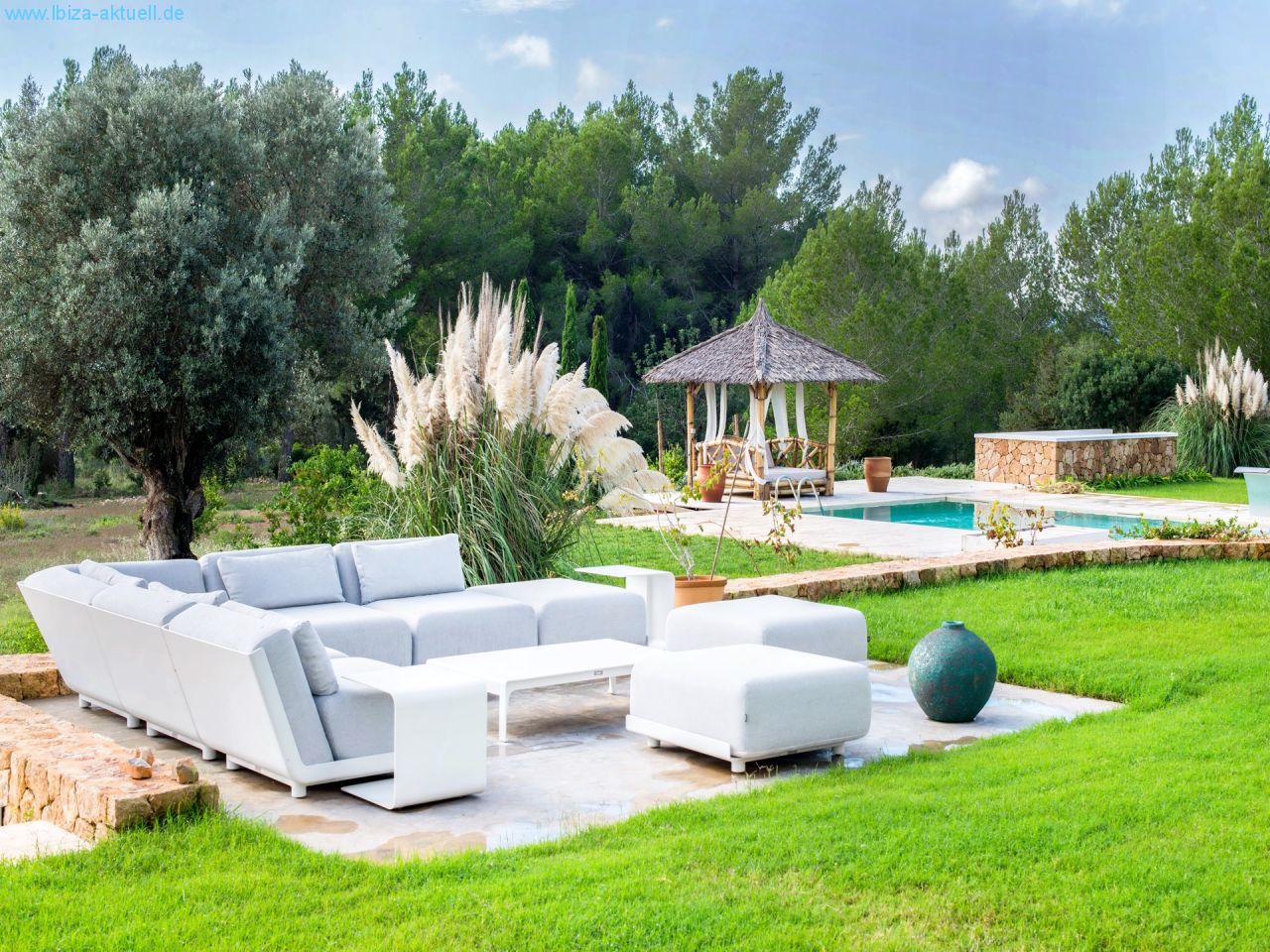 modern sofagroup on the terace infront of the house and large lawn