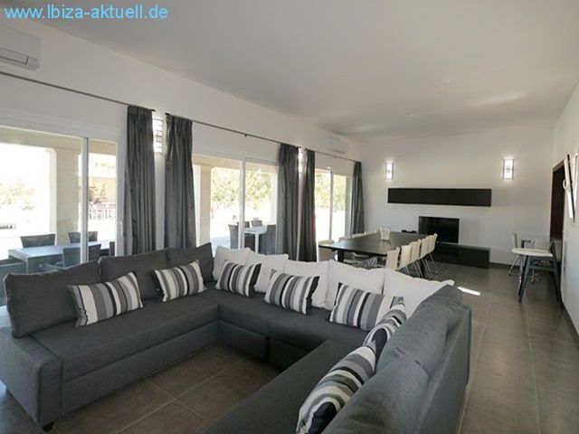 living area, behind dining table with kitchen on the righthandside.  In front the shadowed terace.